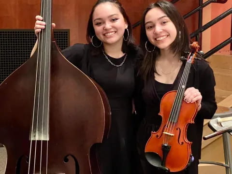 a couple of women holding musical instruments