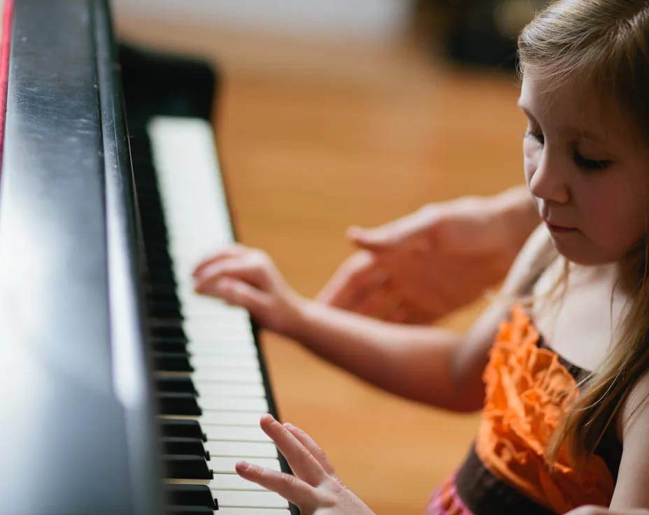 a young girl playing a piano