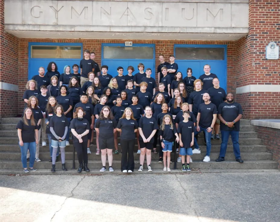 a group of people posing for a photo in front of a building