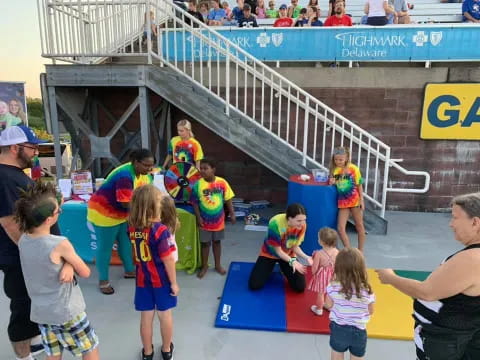 a group of people playing on a mat in front of a crowd