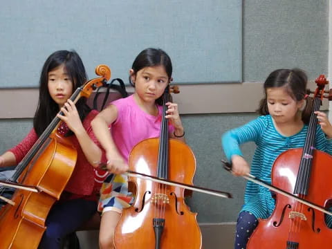 a group of girls playing cellos