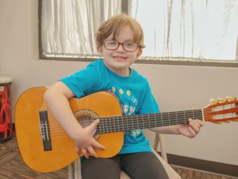 a boy holding a guitar