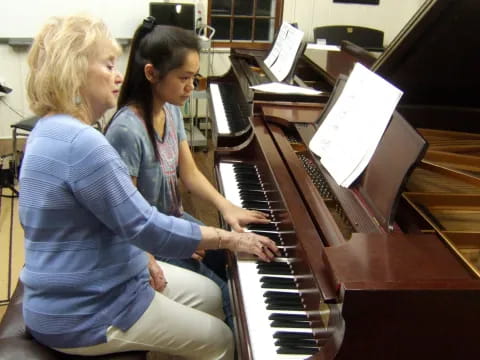 a couple of women playing piano