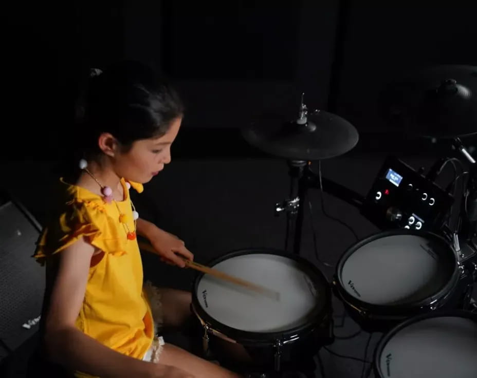 a young girl playing drums