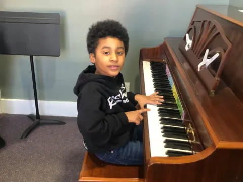 a boy sitting at a piano