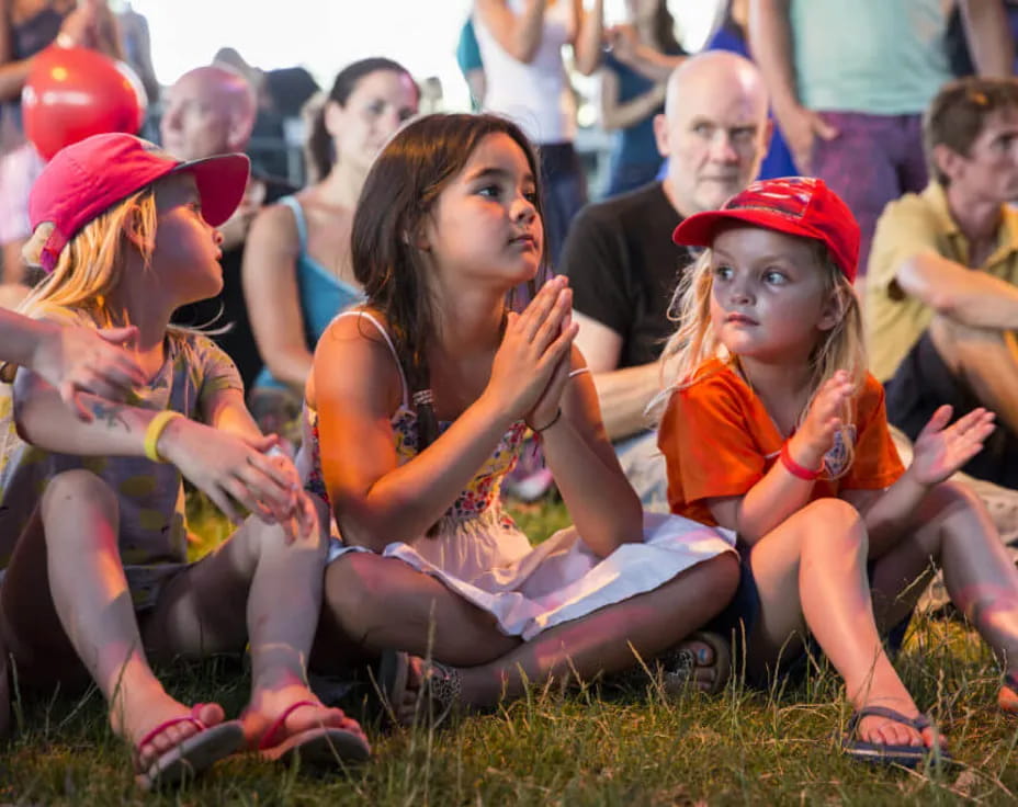 a group of people sitting on the grass