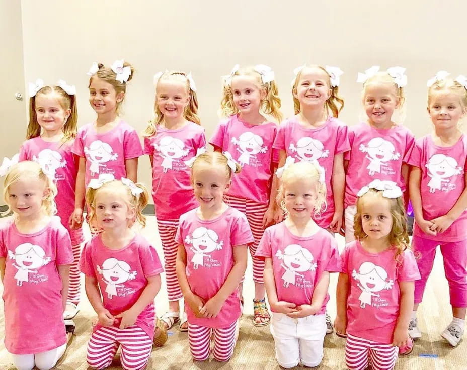a group of children in pink and white clothes