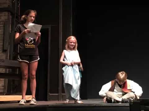 a person and a girl on stage
