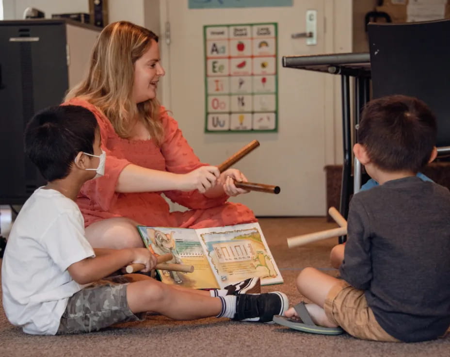 a woman teaching children how to use a toy