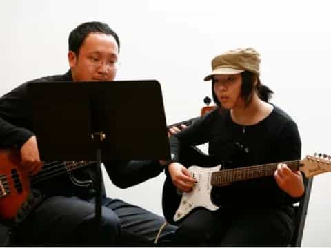 a man and a woman playing guitars