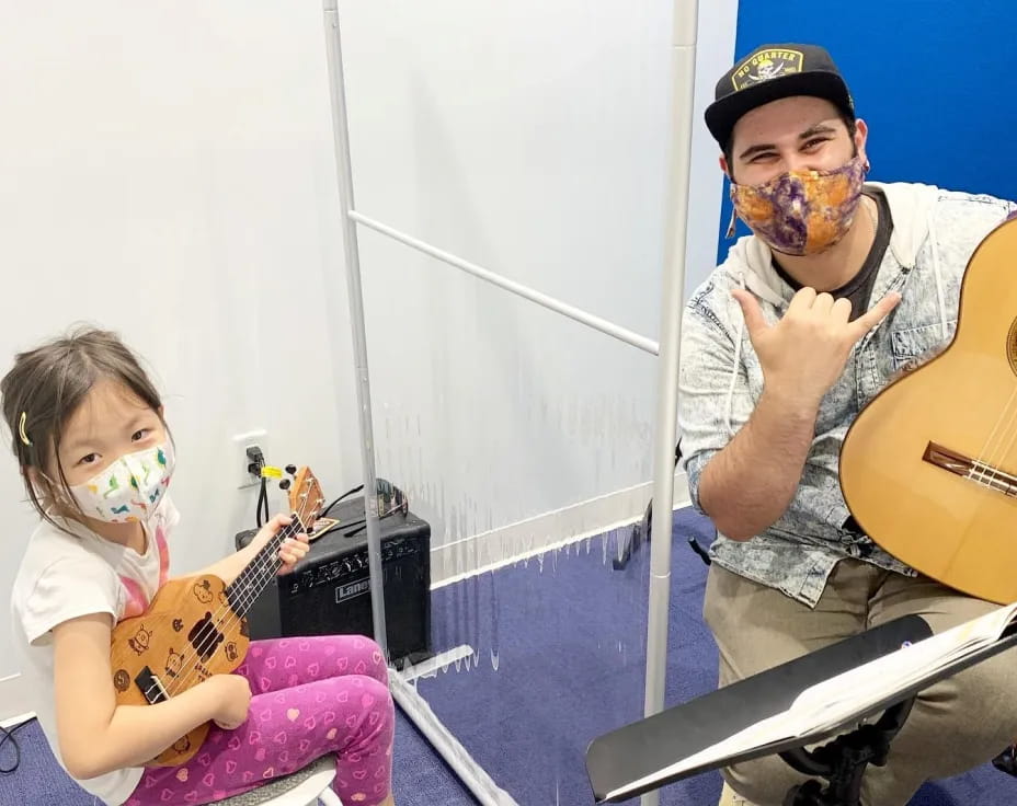 a person and a girl playing guitars