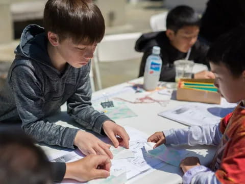 a group of people sitting at a table looking at papers