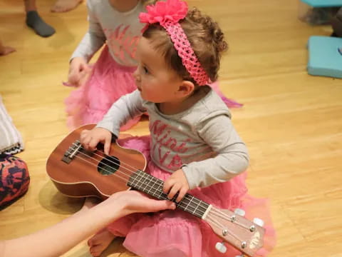 a baby playing a guitar