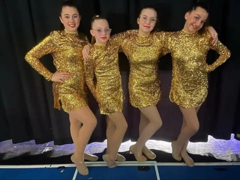 a group of women wearing gold dresses