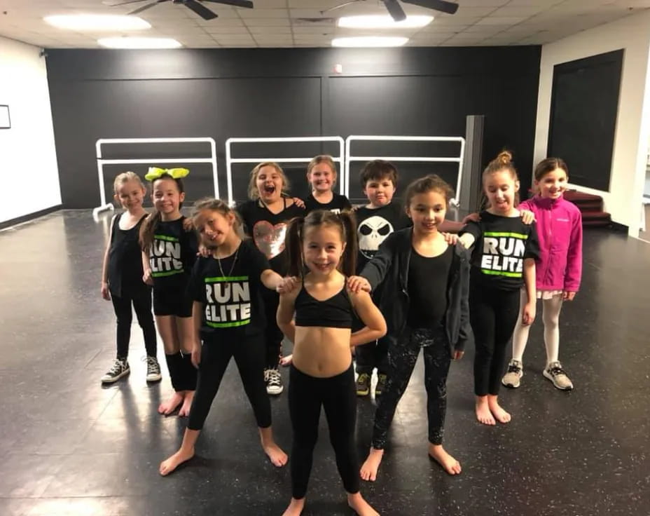 a group of children wearing matching t-shirts and standing in a room