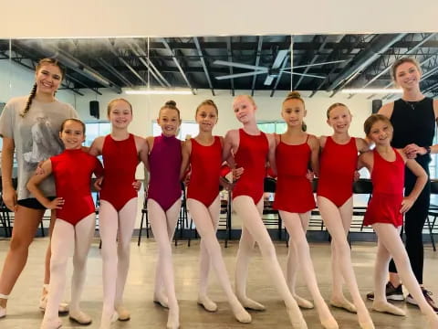 a group of women in red and black leotards posing for a photo