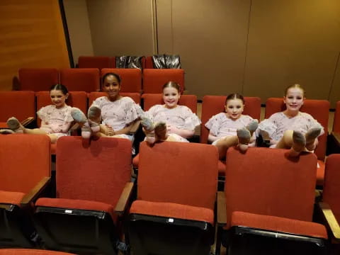 a group of children sitting in chairs