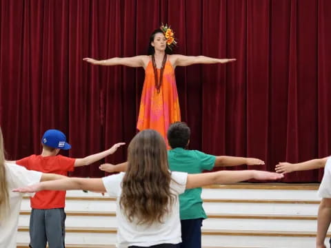 a person standing on a stage with children in front of the