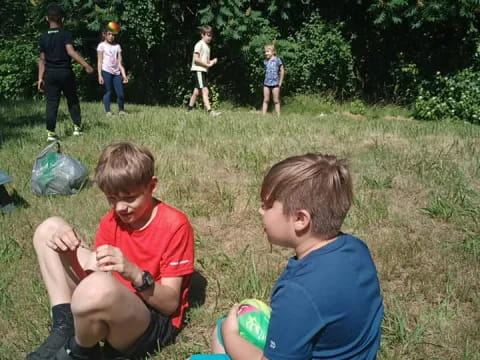 a group of boys sitting on the grass