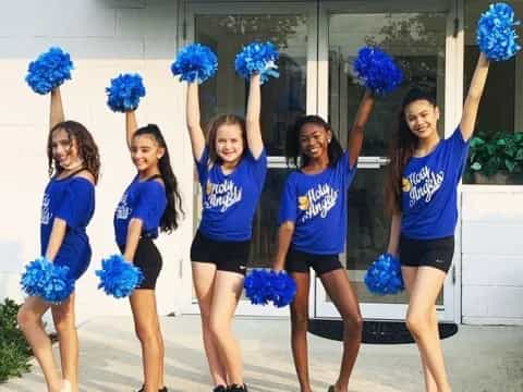 a group of girls wearing matching blue shirts and holding blue flowers