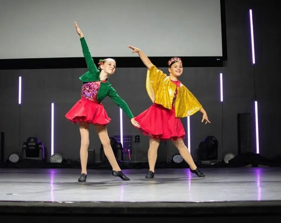 a couple of girls dancing on a stage