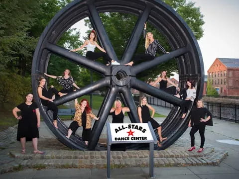 a group of people posing for a photo in front of a large black sculpture