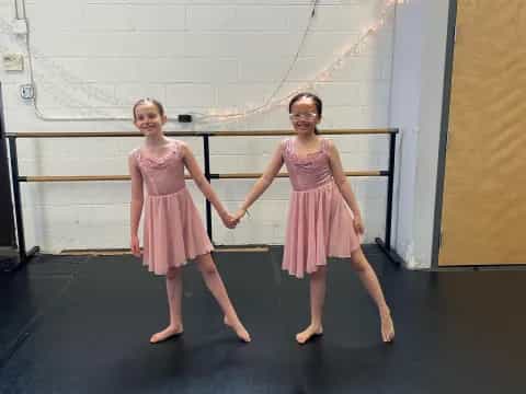 two girls wearing dresses and dancing