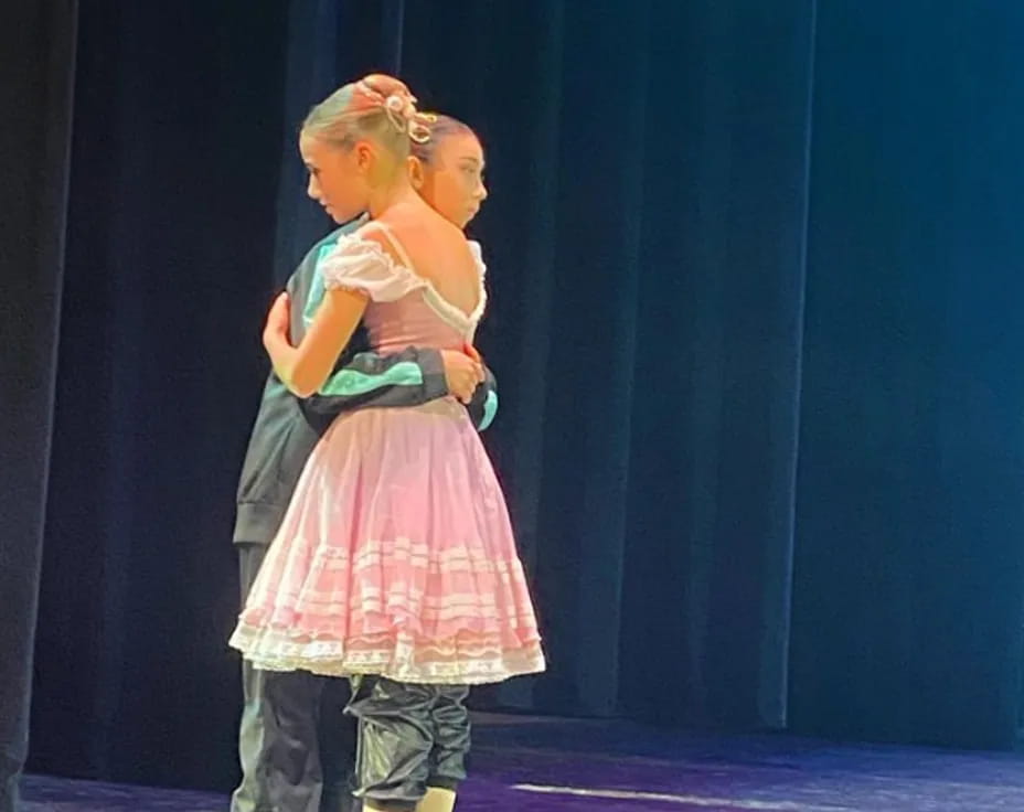 two girls in dresses hugging
