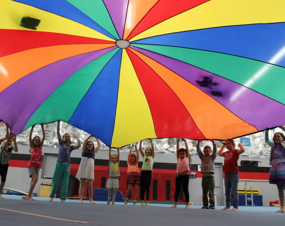 a group of people standing under a colorful umbrella