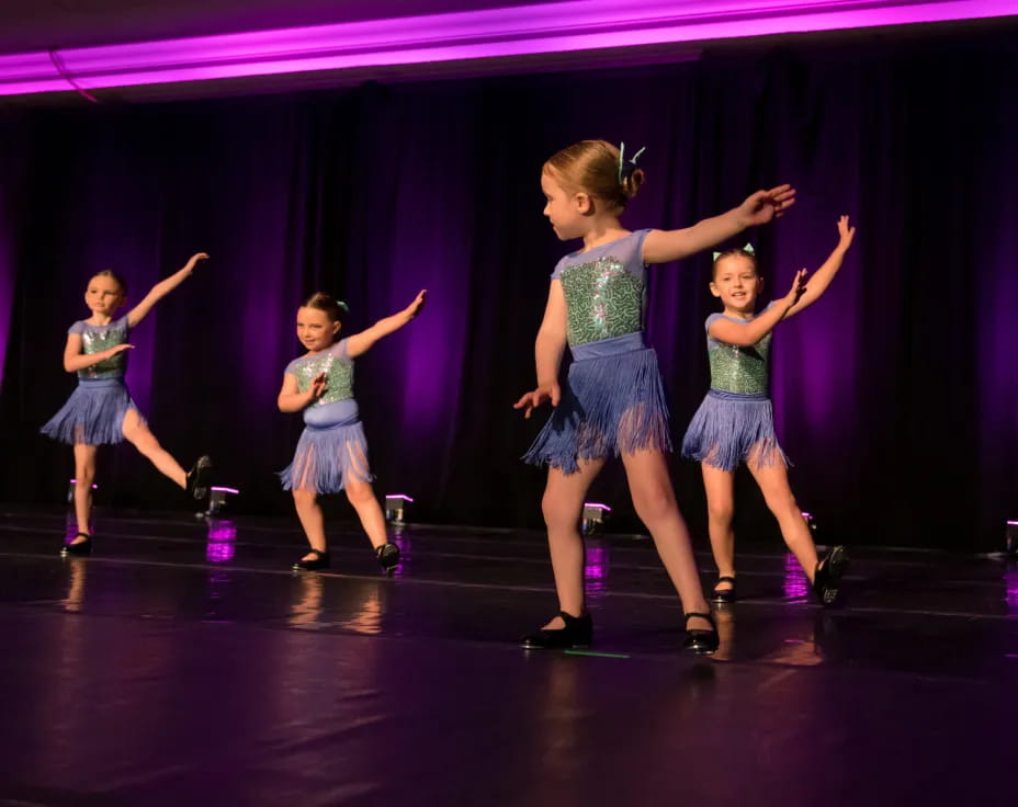 a group of girls dancing on a stage