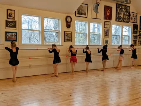 a group of women dancing in a room with large windows