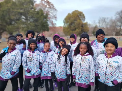 a group of children wearing purple and black clothing