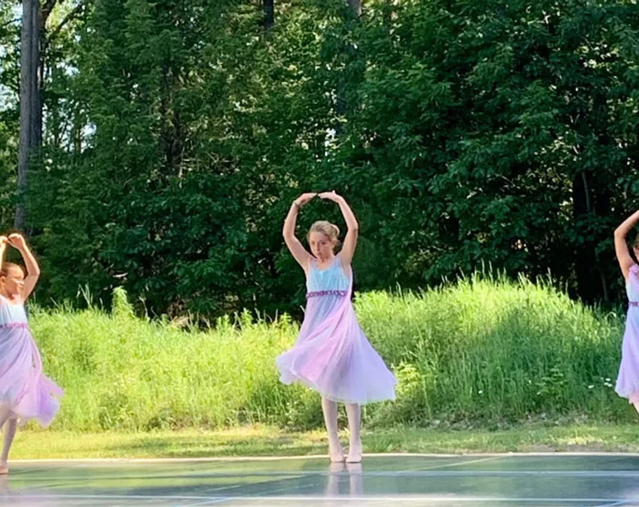 a group of girls in dresses dancing