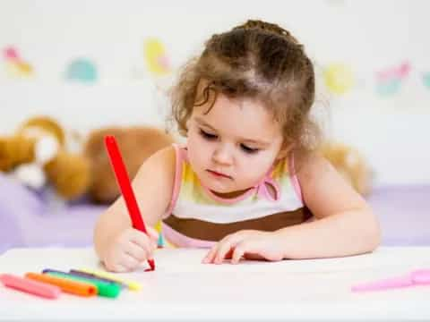 a baby girl coloring on a paper