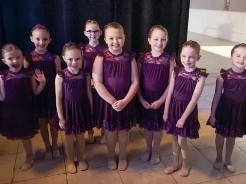 a group of girls in purple dresses