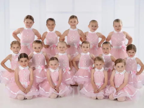 a group of girls in pink dresses