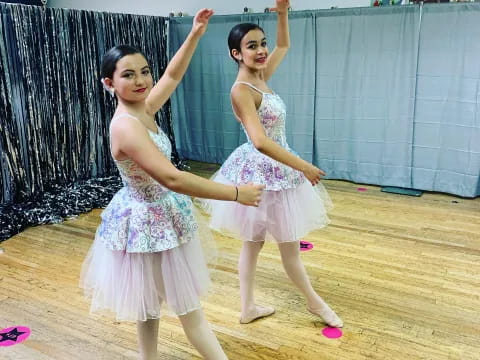 two girls dancing on a wood floor