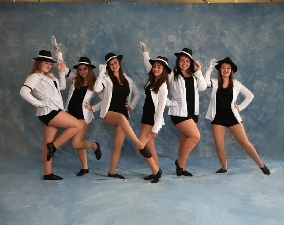 a group of women wearing hats and dancing on ice