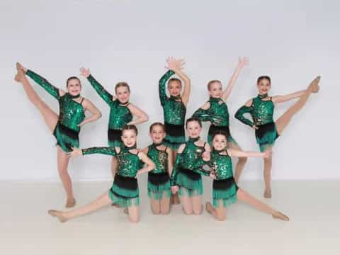 a group of girls in matching green and black outfits