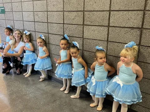 a group of girls in blue dresses