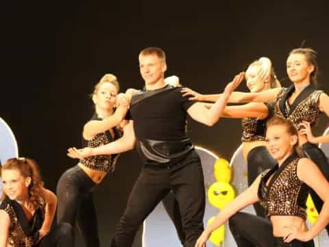 a woman and a group of women dancing on a stage