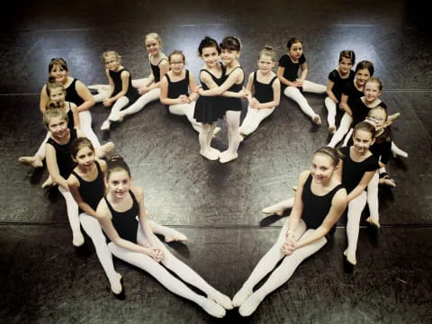 a group of women in black and white dancing on a stage