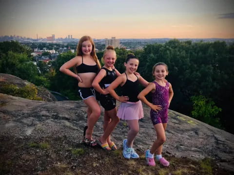 a group of girls posing for a picture on a cliff