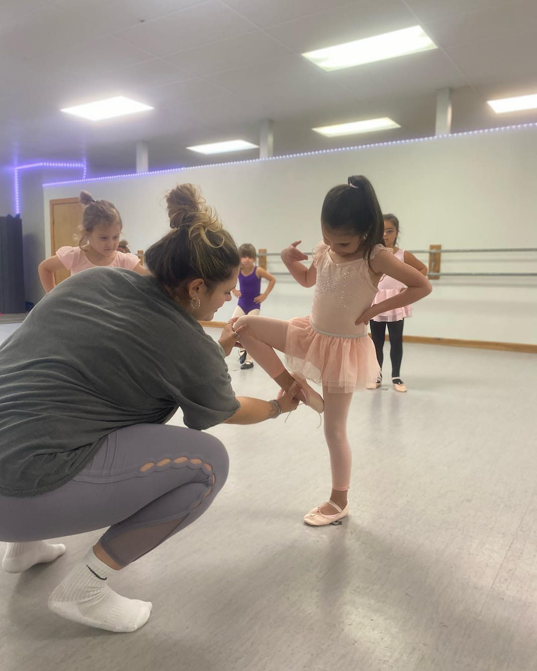 a person kneeling down to touch a girl's hand