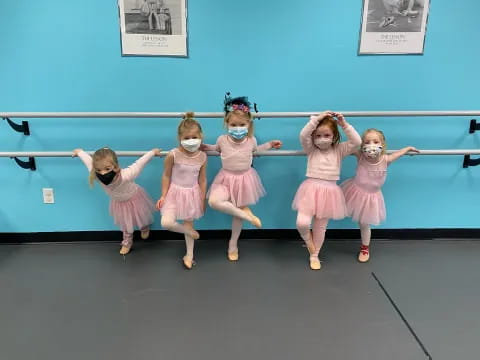 a group of girls in dresses dancing