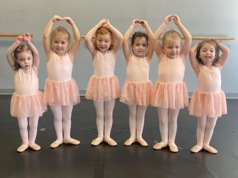 a group of girls wearing dresses and posing for a photo