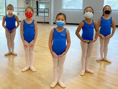a group of women wearing blue scrubs and masks