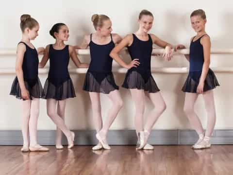 a group of women in matching blue and black dresses