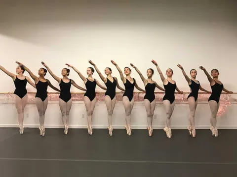 a group of women in black jumping in the air