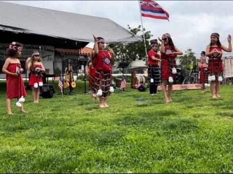 a group of people in red and black dresses dancing in a field